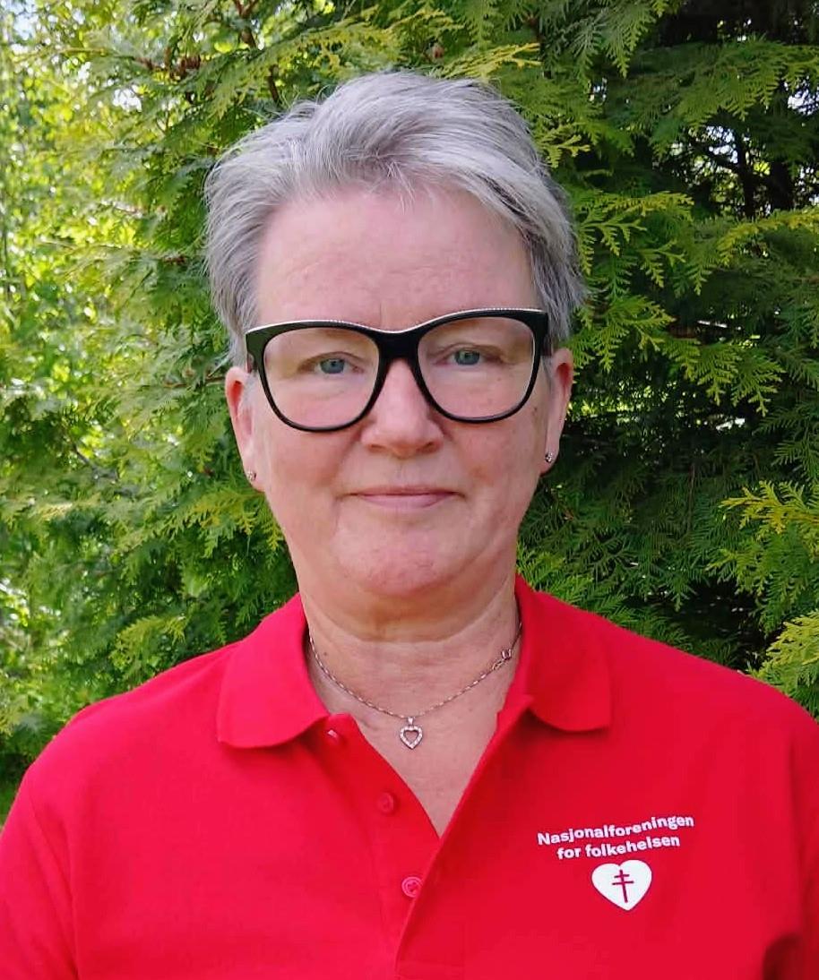 Ei dame med kort, lyst hår, briller og en rød trøye. - Klikk for stort bilde